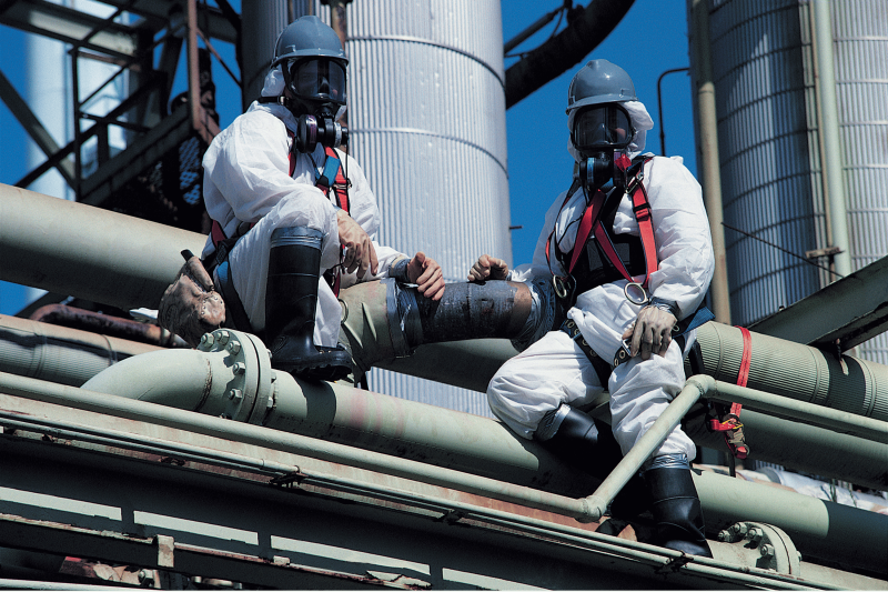 Two asbestos inspectors removing asbestos from a building.