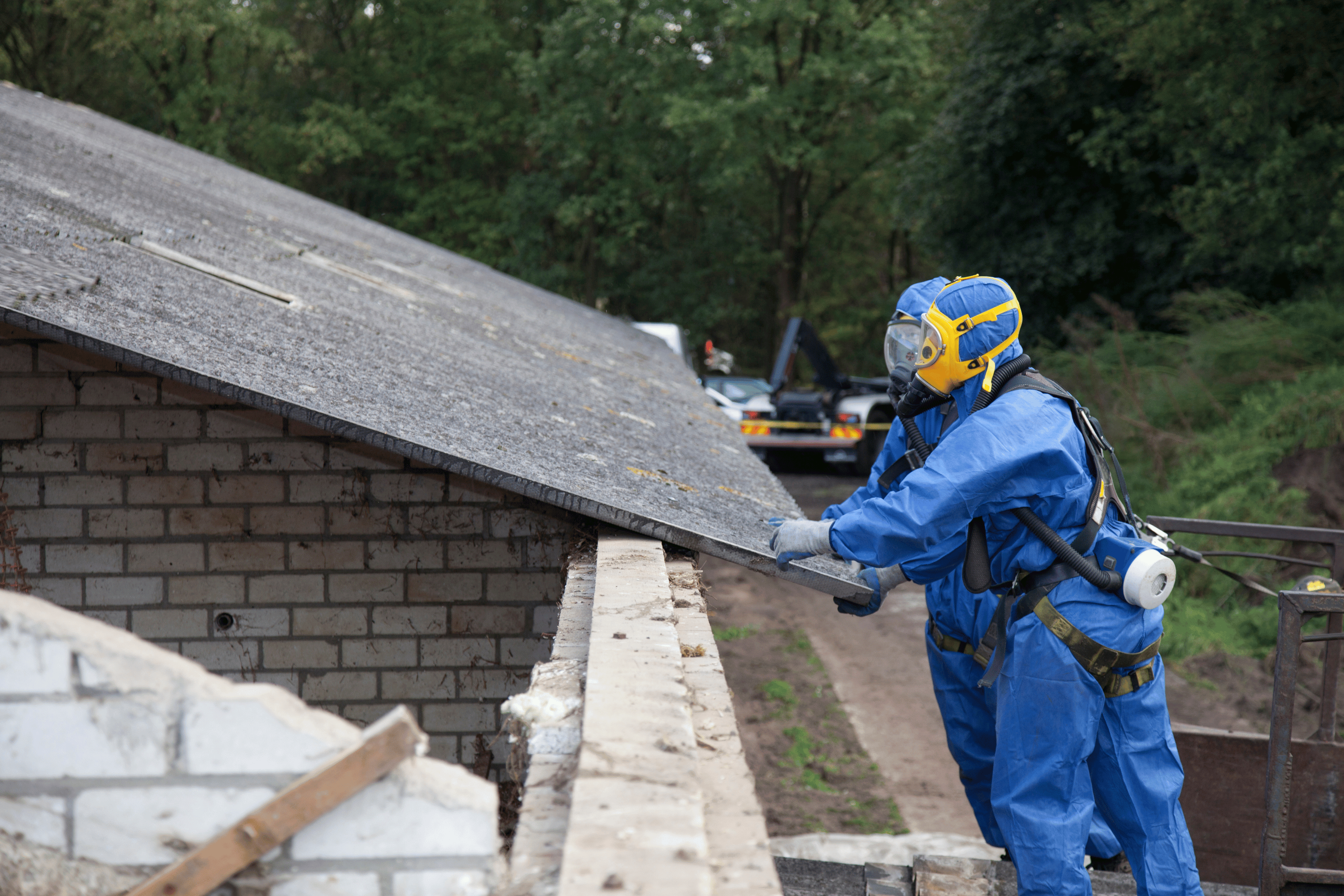 Professional asbestos removalists, removing asbestos sheeting from roof.