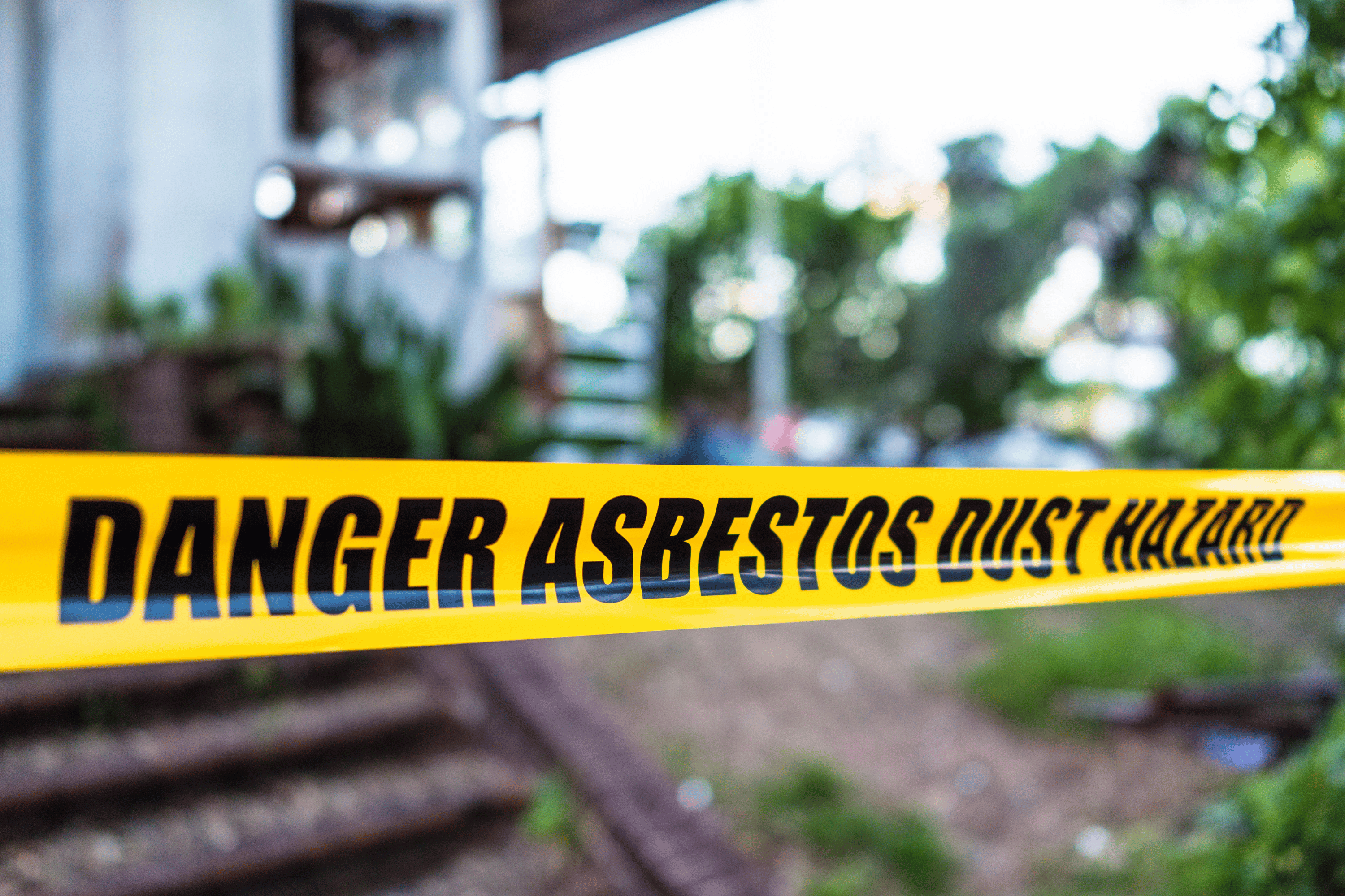 'Danger asbestos dust hazard' yellow tape.